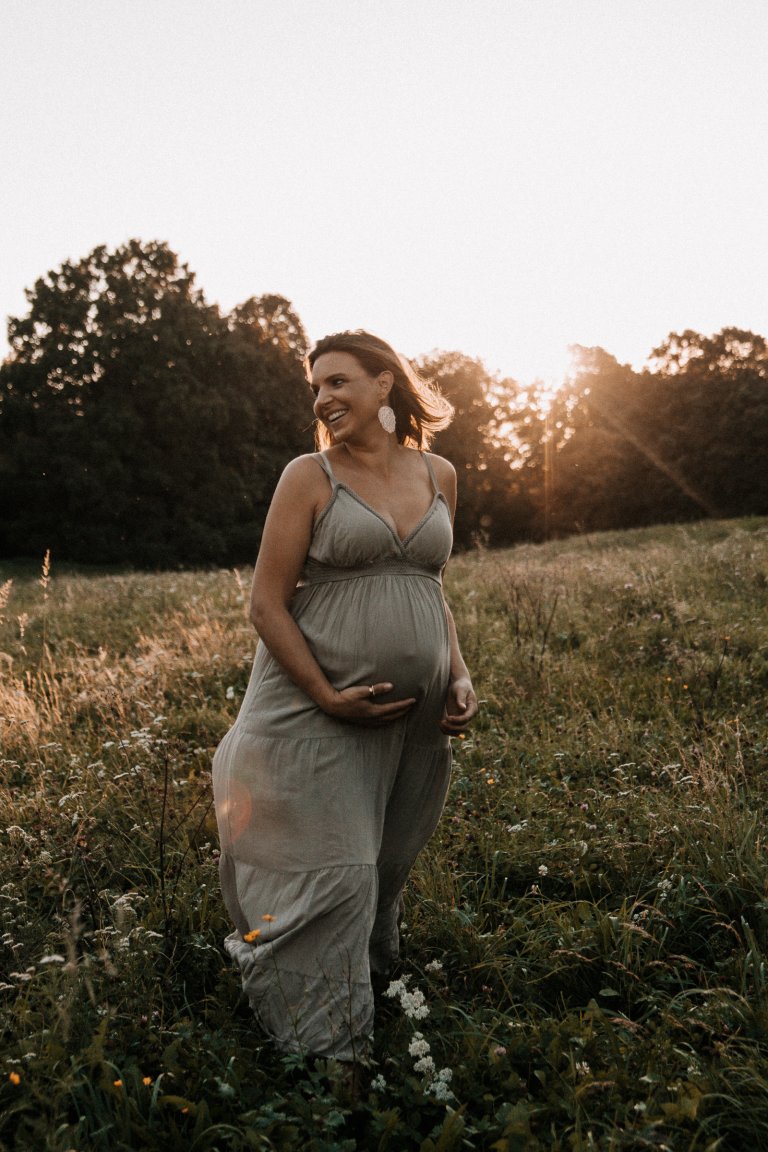 Babybauchschooting München Outdoor schwanger Frau im Sonnenuntergang auf einer Wiese