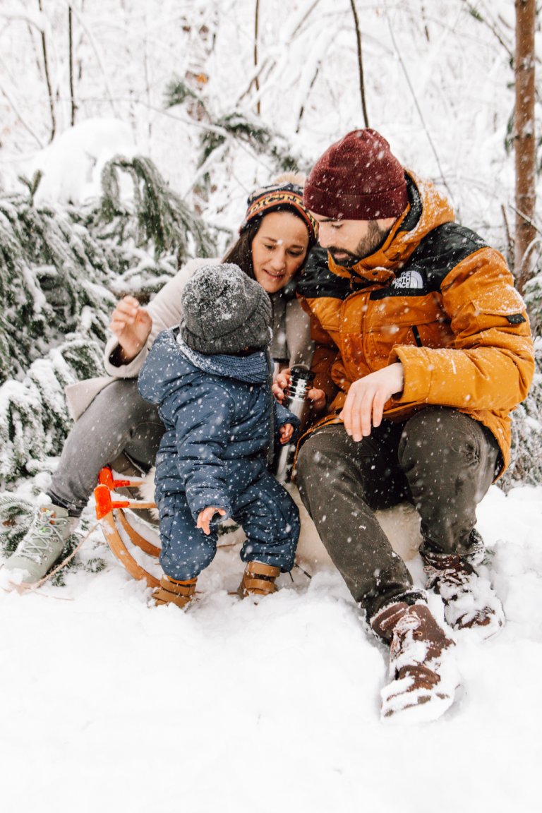 Familie im Schnee auf einem Schlitten